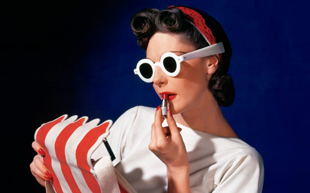 Model Muriel Maxwell in white sunglasses putting on lipstick, we